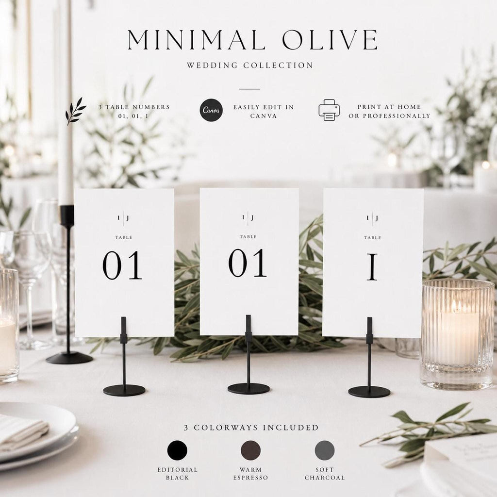 Three white table number signs, each displaying "TABLE 01" in black text, are held by black stands on a white table with a candle and wine glasses.