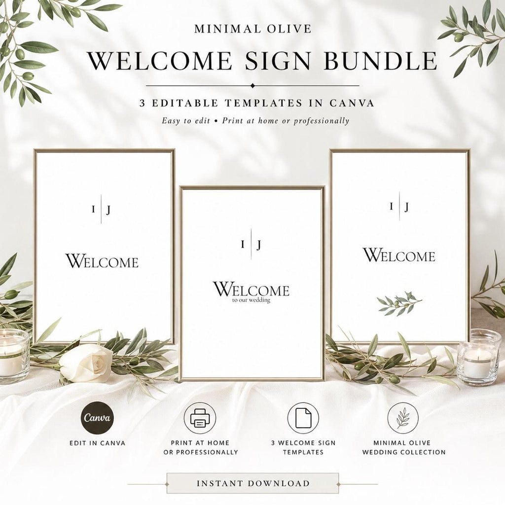 Three framed white "Welcome" signs with olive branch designs are displayed on a white fabric surface, surrounded by candles and white roses.