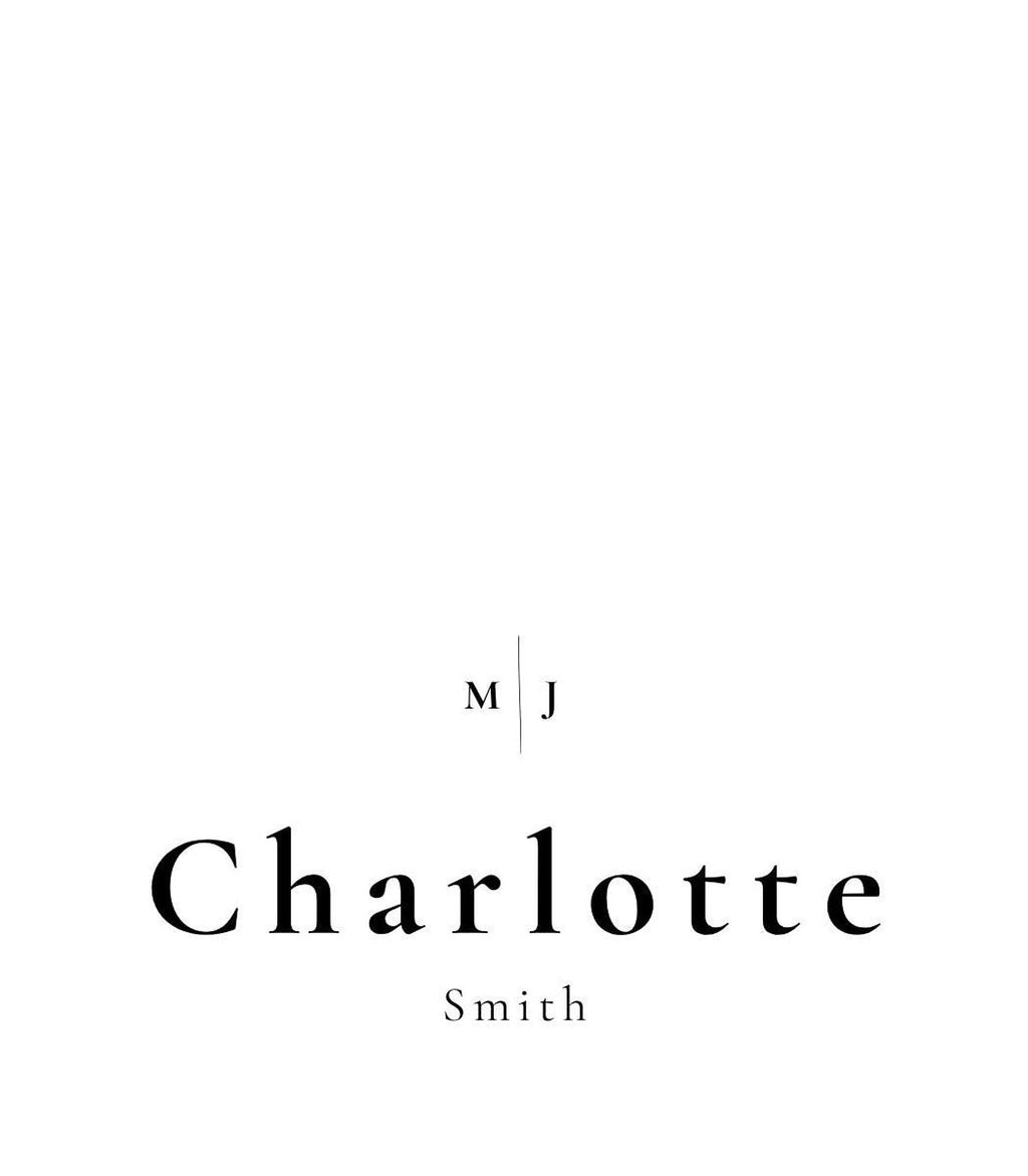 A white place card with the name "Charlotte Smith" in black text, and the initials "M J" in a smaller font above the name.