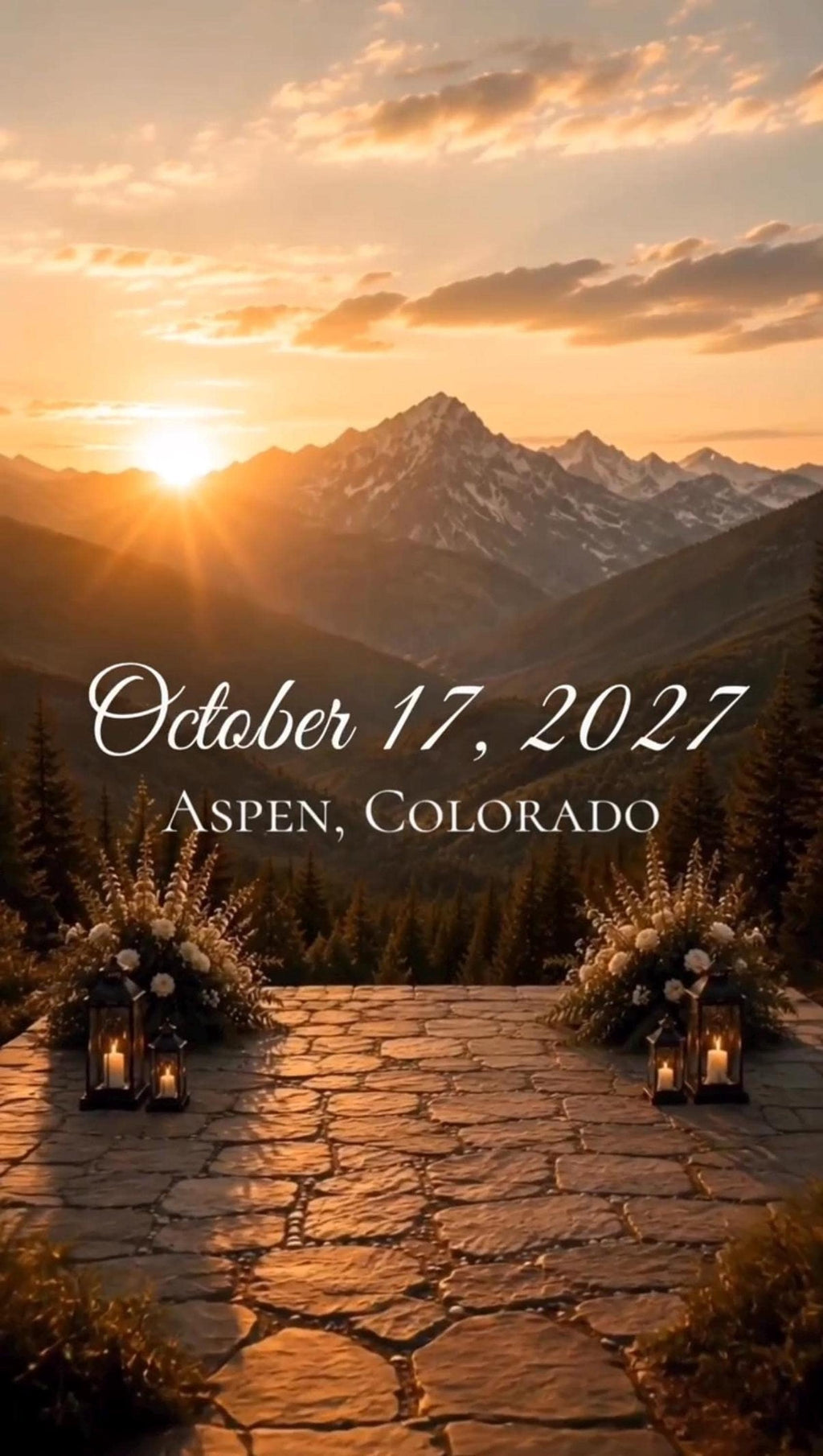 Vertical video still of a stone overlook with lanterns and flowers facing a mountain sunset, displaying the text October 17, 2027 Aspen, Colorado.